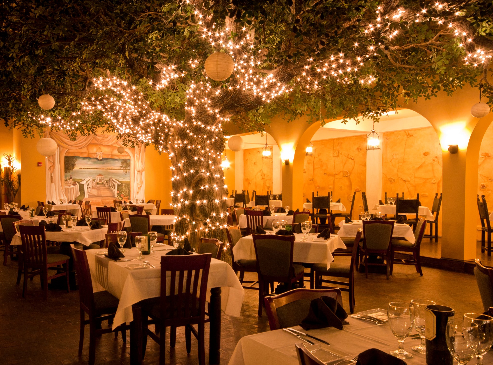 Firefly restaurant dining room in Panama City Beach with elegant tables and illuminated tree